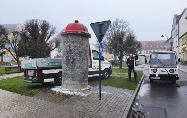 ZGM Słup informacyjny i zaparkowane obok auta ZGM. Z jednego wysiada mężczyzna.